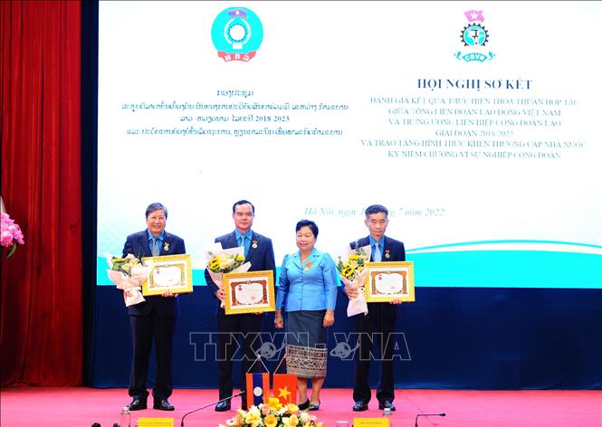 Đồng chí Aly Vong Nor Bun Tham - Uỷ viên Trung ương Đảng Nhân dân Cách mạng Lào, Chủ tịch Trung ương Liên hiệp Công đoàn Lào trao tặng Huân, Huy chương hữu nghị Lào cho Chủ tịch Tổng Liên đoàn Lao động Việt Nam Nguyễn Đình Khang. Ảnh: Minh Đức -–TTXVN