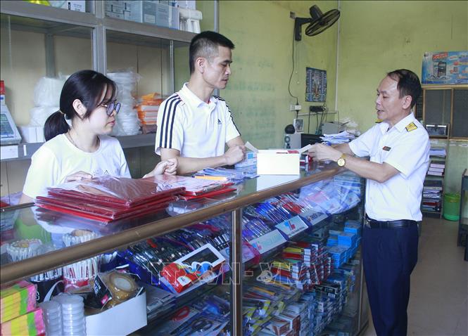 Trong ảnh: Cán bộ ngành thuế tuyên truyền chính sách thuế tại Cửa hàng Văn phòng phẩm Phượng Dũng, thành phố Ninh Bình. Ảnh: Thùy Dung - TTXVN