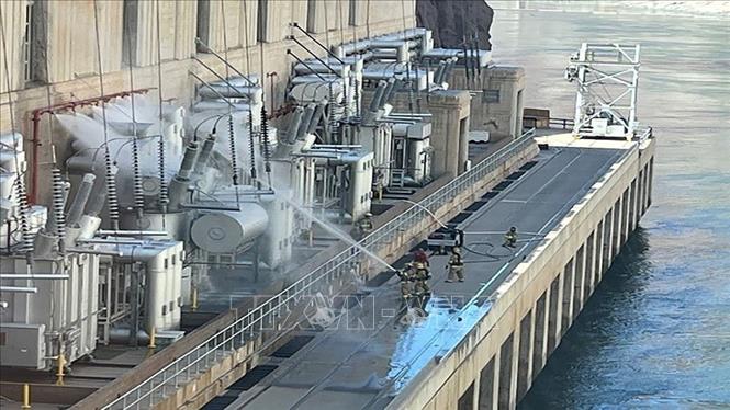 Trong ảnh: Lính cứu hỏa phun nước dập lửa tại hiện trường vụ cháy máy biến áp tại đập Hoover gần thành phố Boulder, bang Nevada, Mỹ ngày 19/7/2022. Ảnh: Reuters/TTXVN