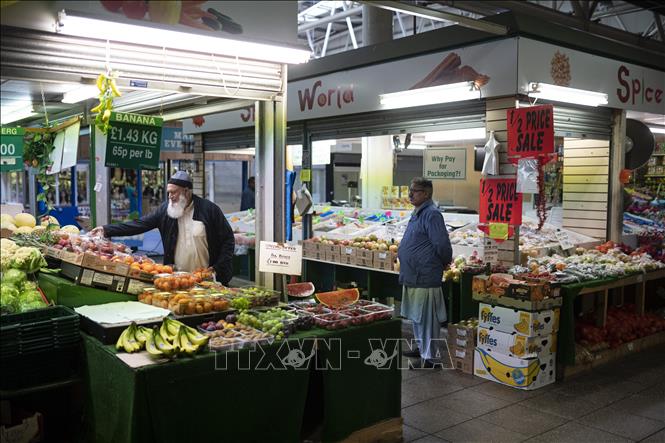 Trong ảnh: Người dân mua sắm tại một khu chợ ở Bradford, Anh ngày 24/5/2022. Ảnh: AFP/TTXVN