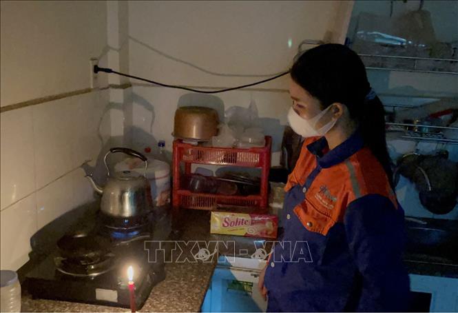 Gia đình chị Dương Thị Vẻ (hộ dân sinh sống tại dãy nhà B13) không đồng ý với mức tăng phí dịch vụ 70% nên đã bị cắt điện, gia đình phải sử dụng nến trong sinh hoạt hằng ngày. Ảnh: Lê Xuân-TTXVN