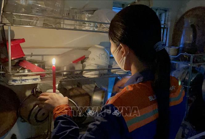 Gia đình chị Dương Thị Vẻ (hộ dân sinh sống tại dãy nhà B13) không đồng ý với mức tăng phí dịch vụ 70% nên đã bị cắt điện, gia đình phải sử dụng nến trong sinh hoạt hằng ngày. Ảnh: Lê Xuân-TTXVN