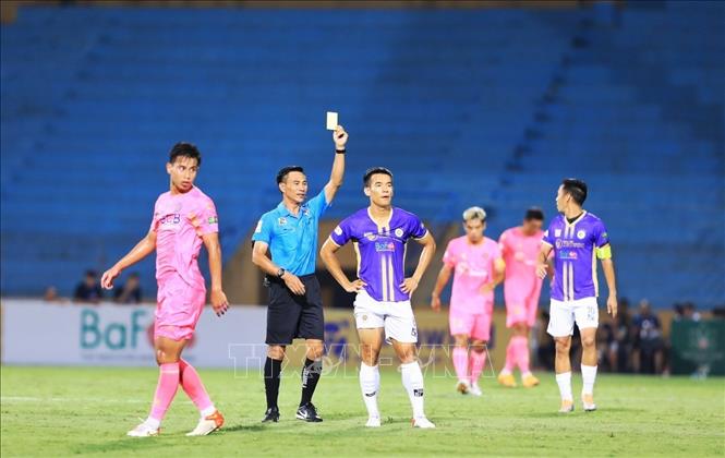 Trong ảnh: Trọng tài Lê Đức Cảnh rút thẻ vàng thổi phạt cầu thủ số 8 Đậu Văn Toàn đội Hà Nội FC do phạm lỗi. Ảnh: Tuấn Anh - TTXVN