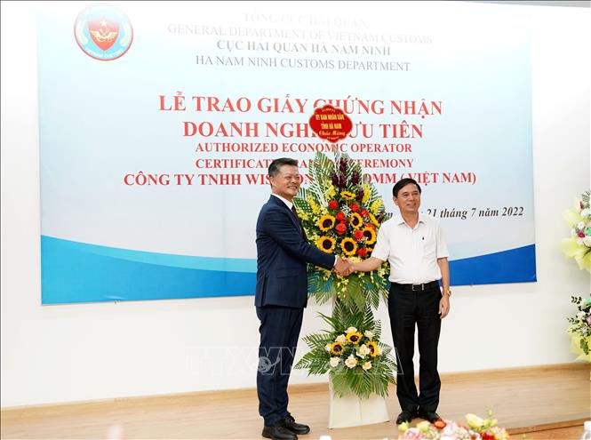 Trong ảnh: Phó Chủ tịch UBND tỉnh Hà Nam Trần Xuân Dưỡng (phải) tặng hoa chúc mừng Công ty TNHH Wistron Infocomm. Ảnh: Nguyễn Chinh - TTXVN