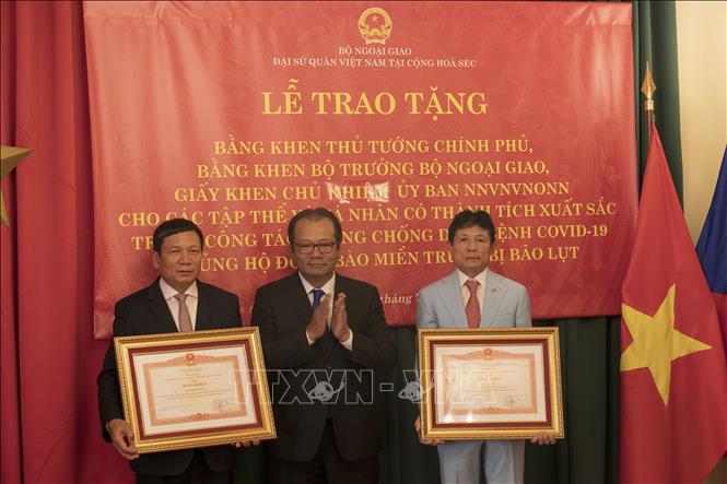 Đại sứ Việt Nam tại CH Séc Thái Xuân Dũng trao Bằng khen của Thủ tướng Chính phủ cho Chủ tịch Liên hiệp Hội người Việt Nam tại châu Âu Hoàng Đình Thắng (ngoài cùng bên trái) và Phó Chủ tịch thứ nhất Hội người Việt Nam tại CH Séc Giang Thành. Ảnh: Ngọc Biên - PV TTXVN tại Séc