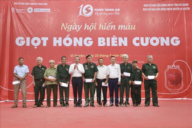 Đại diện Ban tổ chức trao quà cho người có công, đại diện gia đình chính sách tại huyện Vị Xuyên. Ảnh: Minh Quyết - TTXVN
