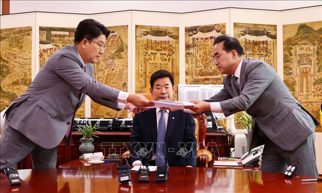 Trong ảnh: Chủ tịch Quốc hội Hàn Quốc Kim Jin-pyo (giữa) chứng kiến quyền Chủ tịch đảng Quyền lực Quốc dân (PPP) cầm quyền Kweon Seong-dong (trái) và đại diện đảng Dân chủ (DP) đối lập chính Park Hong-keun trao đổi văn bản thoả thuận phân chia quyền lực, tại Seoul, ngày 22/7/2022. Ảnh: YONHAP/TTXVN 