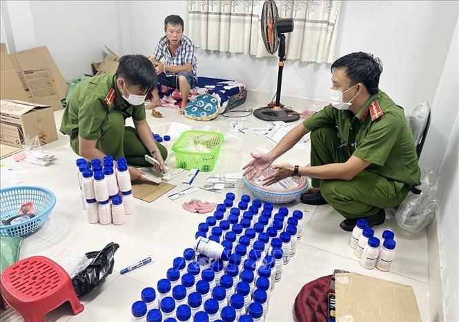 Lực lượng chức năng kiểm đếm số thuốc bảo vệ thực vật giả tại nơi ở của Giác. Ảnh: Công Mạo-TTXVN