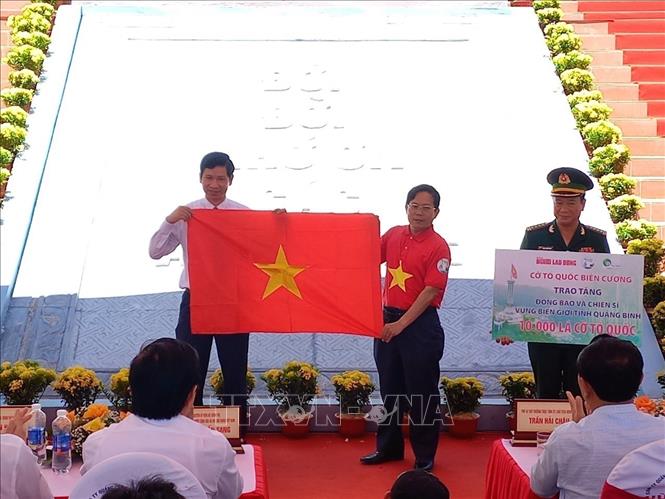 Tặng cờ tổ quốc cho đồng bào chiến sĩ vùng biên cương tỉnh Quảng Bình. Ảnh Đức Thọ -TTXVN