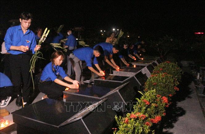 Trong ảnh: Đoàn viên, thanh niên tham gia thắp nến tri ân các Anh hùng liệt sỹ tại Nghĩa trang Liệt sỹ tỉnh Vĩnh Long. Ảnh: Lê Thúy Hằng - TTXVN