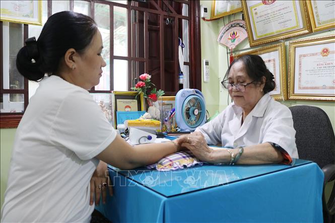 Trong ảnh: Cựu chiến binh, lương y Cao Thị Thanh Mai khám, chữa bệnh cho bệnh nhân. Ảnh: Nguyễn Thành – TTXVN