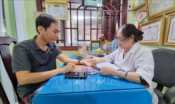 Trong ảnh: Cựu chiến binh, lương y Cao Thị Thanh Mai khám, chữa bệnh cho bệnh nhân. Ảnh: Nguyễn Thành – TTXVN