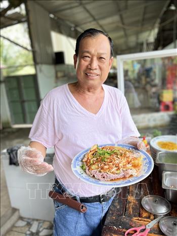Trong ảnh: Ông Huỳnh Hữu Hoài với món pizza hủ tiếu độc quyền. Ảnh: TTXVN phát