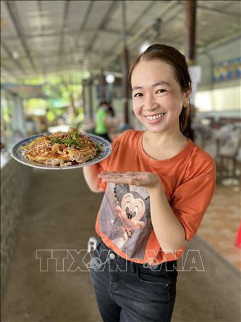 Trong ảnh: Du khách với món pizza hủ tiếu độc quyền của lò hủ tiếu Sáu Hoài. Ảnh: TTXVN phát