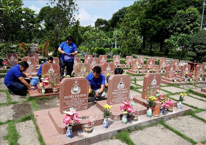 Trong ảnh: Các đoàn viên thanh niên chăm sóc mộ phần các Anh hùng, liệt sĩ. Ảnh: Hồng Đạt - TTXVN
