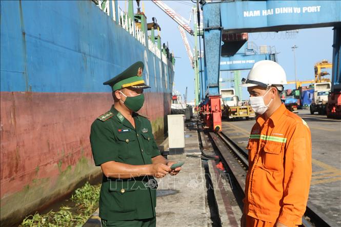 Trong ảnh: Thượng úy Dương Văn Sự kiểm tra thông tin của người lao động làm việc trên tàu tại khu vực biên giới biển. Ảnh: Minh Thu- TTXVN