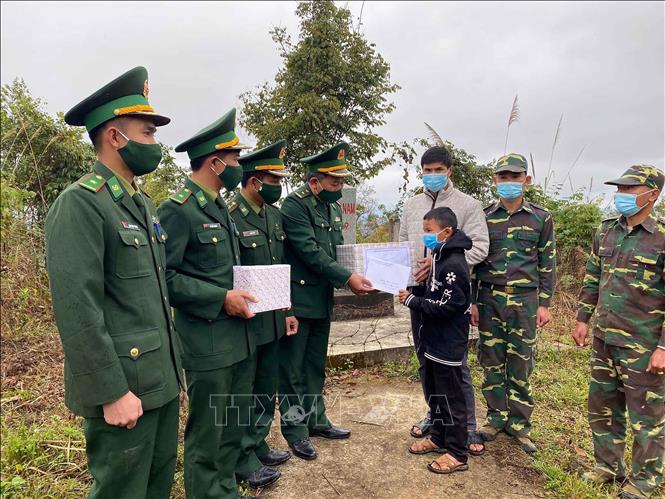 Cán bộ chiến sĩ Đồn Biền phòng Mường Lèo, Bộ Chỉ huy Bộ đội Biên phòng tỉnh Sơn La hỗ trợ tiền và đồ dùng học tập cho em Thào-Thanh Lò-Khăm-Thun, cụm bản Nà Son, huyện Phôn Thoong, tỉnh Luông Pha Băng, Lào. Ảnh: TTXVN phát