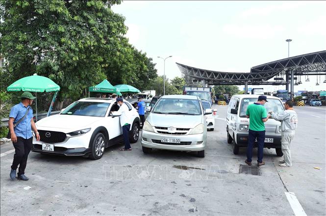 Rất nhiều phương tiện đi qua trạm thu phí BOT Pháp vân - Cầu Giẽ sẽ được nhân viên Công ty TNHH Thu phí tự động VETC hướng dẫn dán thẻ VETC (thu phí dịch vụ sử dụng đường bộ theo hình thức điện tử tự động không dừng). Ảnh: Phạm Kiên - TTXVN