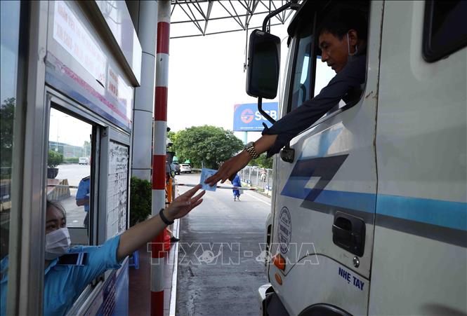 Phương tiện chưa dán thẻ VETC đi qua Trạm thu phí BOT Pháp Vân - Cầu Giẽ sẽ phải đi làn riêng và được nhân viên thu hướng dẫn dán thẻ VETC (thu phí dịch vụ sử dụng đường bộ theo hình thức điện tử tự động không dừng). Ảnh: Phạm Kiên - TTXVN
