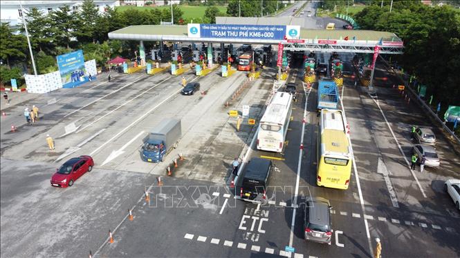 Các phương tiện đã dán thẻ VETC lưu thông qua làn thu phí tự động ETC tại trạm thu phí BOT Nội Bài - Lào Cai. Ảnh: TTXVN phát