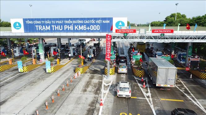 Các phương tiện đã dán thẻ VETC lưu thông qua làn thu phí tự động ETC tại trạm thu phí BOT Nội Bài - Lào Cai. Ảnh: TTXVN phát