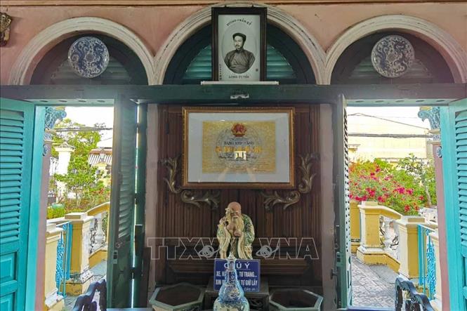 Ảnh ông Dương Chấn Kỷ, người đã có công xây dựng ngôi nhà hoàn chỉnh như hiện nay và Bằng xếp hạng di tích quốc gia được treo trang trọng trên ô cửa ở gian giữa nhà ngoài. Ảnh: Thanh Tùng - TTXVN