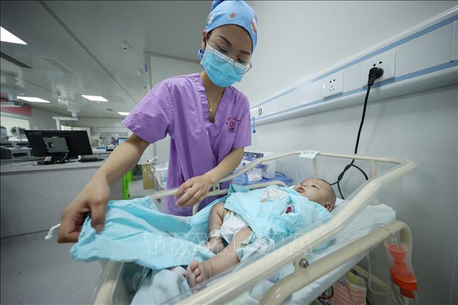 Trong ảnh: Nhân viên y tế chăm sóc trẻ sơ sinh tại bệnh viện ở tỉnh Quý Châu, Trung Quốc. Ảnh: AFP/TTXVN