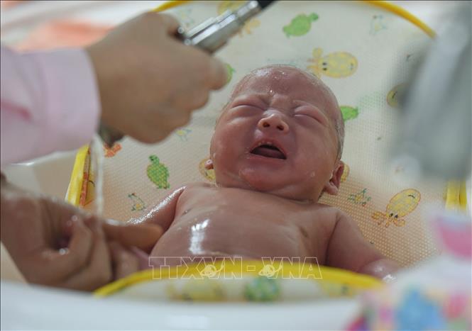 Trong ảnh: Nhân viên y tế chăm sóc em bé sơ sinh tại bệnh viện ở tỉnh An Huy, Trung Quốc. Ảnh: AFP/TTXVN