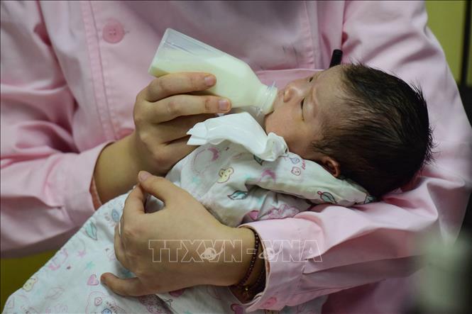 Trong ảnh: Nhân viên y tế chăm sóc em bé sơ sinh tại bệnh viện ở tỉnh An Huy, Trung Quốc. Ảnh: AFP/TTXVN