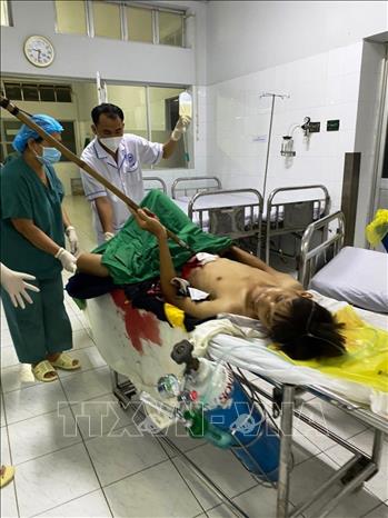 Bệnh nhân L.H.P bị dao cạo mủ cao su đâm thủng bụng vẫn còn dính vào người trước khi phẫu thuật. Ảnh: TTXVN phát