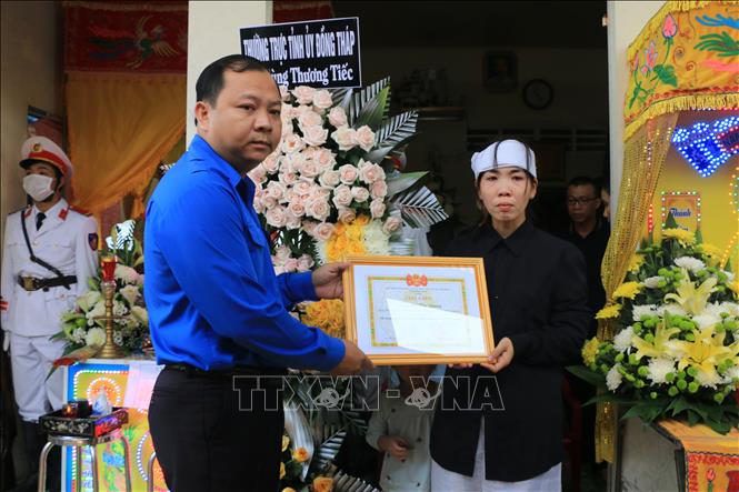Trong ảnh: Chị Tống Thị Hồng Nhung (vợ của đồng chí Hồ Tấn Dương) nhận Giấy khen của Ban Chấp hành Tỉnh đoàn Đồng Tháp. Ảnh: Nhựt An - TTXVN