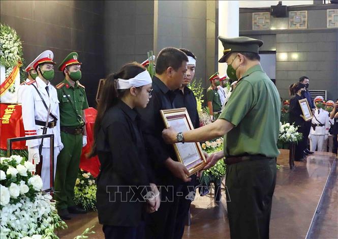 Đại tướng Tô Lâm, Ủy viên Bộ Chính trị, Bộ trưởng Bộ Công an trao Huân chương Chiến công hạng Nhất cho gia đình Thượng úy Đỗ Đức Việt (Cán bộ Đội Cảnh sát PCCC và CNCH, Công an quận Cầu Giấy). Ảnh: Phạm Kiên - TTXVN