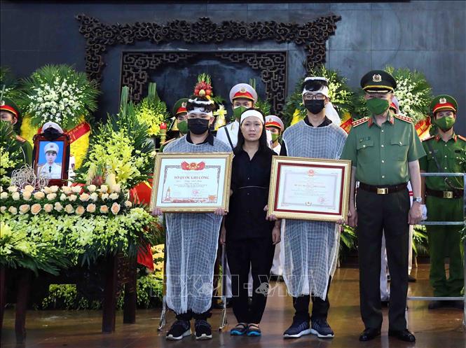 Đại tướng Tô Lâm, Ủy viên Bộ Chính trị, Bộ trưởng Bộ Công an trao Huân chương Chiến công hạng Nhất cho gia đình liệt sĩ, Thượng tá Đặng Anh Quân (Đội trưởng Đội Cảnh sát PCCC và CNCH, Công an quận Cầu Giấy). Ảnh: Phạm Kiên - TTXVN