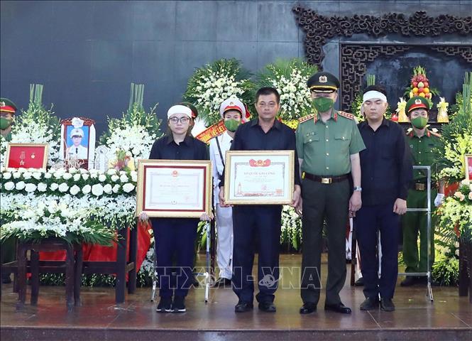 Đại tướng Tô Lâm, Ủy viên Bộ Chính trị, Bộ trưởng Bộ Công an trao Bằng Tổ quốc ghi công cho gia đình Thượng úy, Liệt sĩ Đỗ Đức Việt (Cán bộ Đội Cảnh sát PCCC và CNCH, Công an quận Cầu Giấy). Ảnh: Phạm Kiên - TTXVN