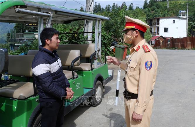 Trong ảnh: Cảnh sát giao thông thị xã Sa Pa nhắc nhở các nhà xe kinh doanh xe điện không được phép chở khách đến các điểm du lịch chưa được đăng ký tuyến hoạt động. Ảnh: Quốc Khánh - TTXVN