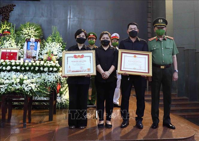 Đại tướng Tô Lâm, Ủy viên Bộ Chính trị, Bộ trưởng Bộ Công an trao Bằng Tổ quốc ghi công cho gia đình Hạ sĩ, Liệt sĩ Nguyễn Đình Phúc (Chiến sĩ nghĩa vụ, Đội Cảnh sát PCCC và CNCH, Công an quận Cầu Giấy). Ảnh: Phạm Kiên - TTXVN
