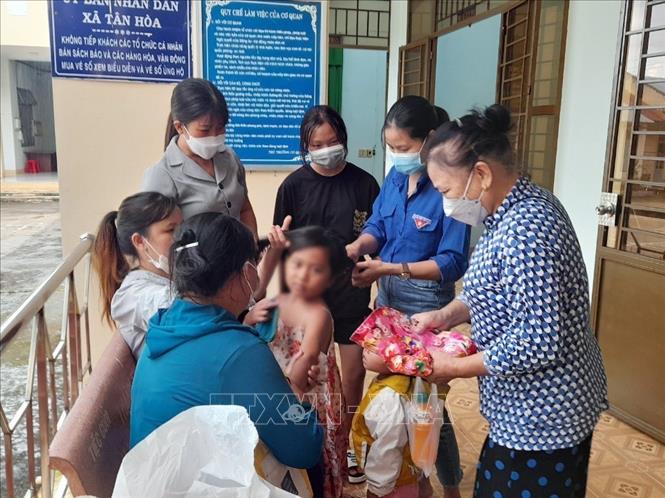 Trong ảnh: Các hội, đoàn thể của huyện và xã Tân Hòa sửa soạn cho bé L.Y.D trước khi bé về quê cùng cha ruột. Ảnh: Đậu Tất Thành – TTXVN

