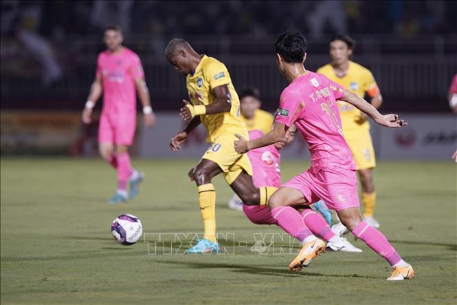 Trong ảnh: Pha tranh bóng giữa cầu thủ đội bóng đá Sài Gòn FC (áo hồng) với đội bóng Hoàng Anh Gia Lai (áo vàng). Ảnh: Thanh Vũ – TTXVN 
