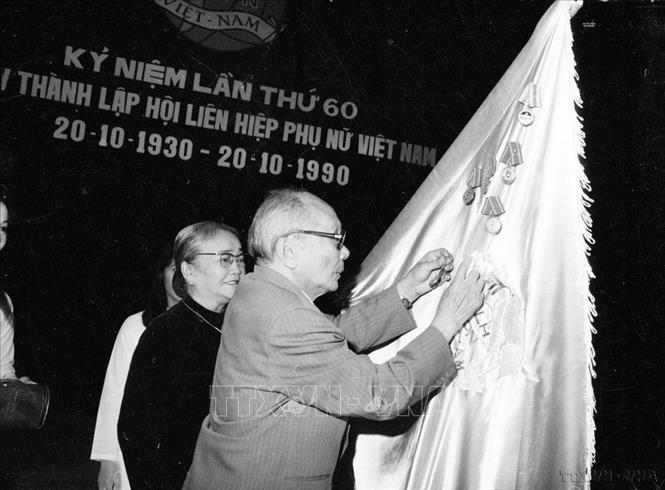 Chủ tịch Hội đồng Nhà nước Võ Chí Công gắn Huân chương Lao động hạng Nhất lên lá cờ truyền thống của Hội Liên hiệp Phụ nữ Việt Nam (18/10/1990). Ảnh: Kim Hùng - TTXVN