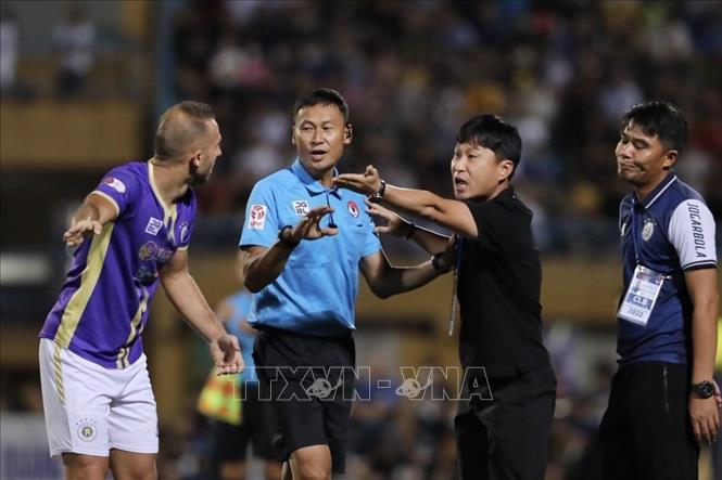 Ban huấn luyện và các cầu thủ Hà Nội phản ứng tình huống phạm lỗi nguy hiểm của tiền vệ Hồng Duy (số 7, HAGL). Ảnh: Minh Quyết - TTXVN