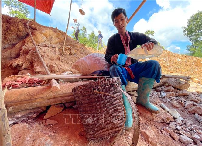 Một phu vàng tạm nghỉ uống nước vào buổi trưa ở điểm khai thác vàng Nậm Khá, xã Mù Cả, huyện Mường Tè, tỉnh Lai Châu. Ảnh: Nhóm PV TTXVN tại Lai Châu