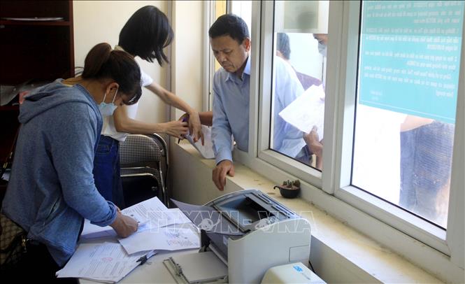 Trong ảnh: Các chủ phương tiện có hộ khẩu thường trú tại huyện Kiến Xương và  Tiền Hải (Thái Bình) làm các thủ tục để được miễn phí vé qua trạm BOT 39B Thanh Nê. Ảnh: Thế Duyệt- TTXVN  