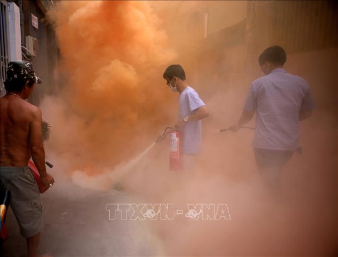 Trong ảnh: Sau khi nghe báo động, người dân hẻm 62 Huỳnh Tịnh Của nhanh chóng lấy bình chữa cháy xách tay khống chế ngọn lửa trong tình huống giả định.
Ảnh: Thành Chung - TTXVN