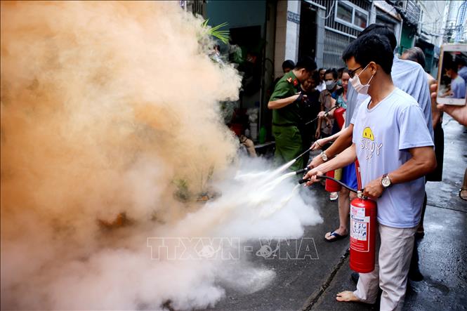 Trong ảnh: Sau khi nghe báo động, người dân hẻm 62 Huỳnh Tịnh Của nhanh chóng lấy bình chữa cháy xách tay khống chế ngọn lửa trong tình huống giả định.
Ảnh: Thành Chung - TTXVN