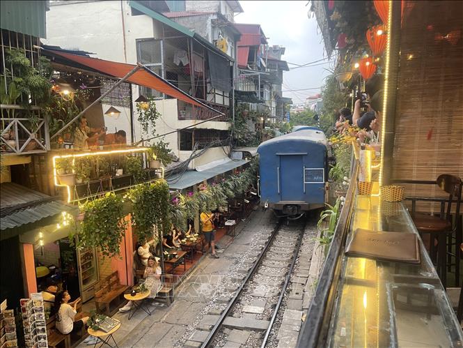 A train runs through the cafe street. VNA Photo: Tuyết Mai