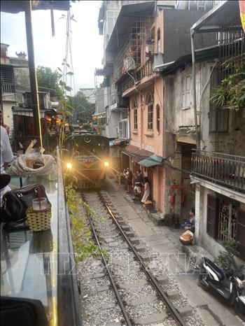 A train runs through the cafe street. VNA Photo: Tuyết Mai