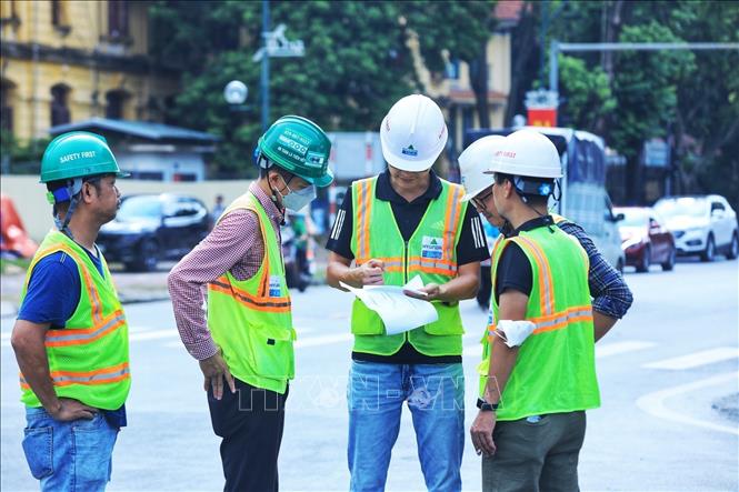 Cán bộ Sở Giao thông Vận tải Hà Nội trao đổi thông tin về tổ chức phân làn trên đoạn phố Trần Hưng Đạo. Ảnh: Tuấn Anh - TTXVN