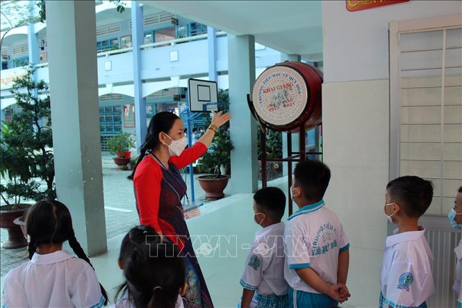 Trong ảnh: Cô giáo giới thiệu cho học sinh về trống trường. Ảnh: Hữu Chí - TTXVN