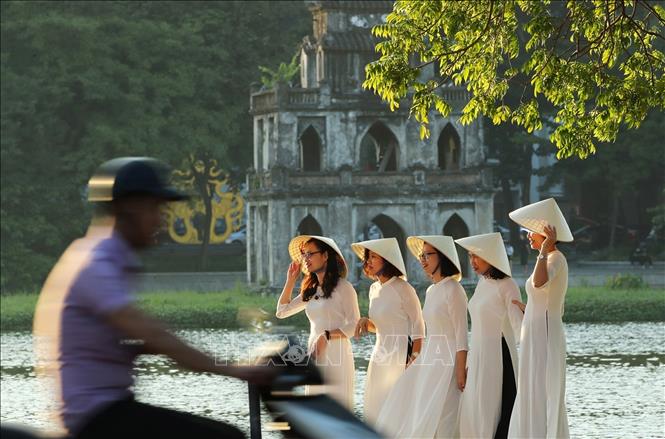 Girls in traditional ao dai (long dress) on Hoan Kiem Lake area. VNA Photo: Lâm Khánh 