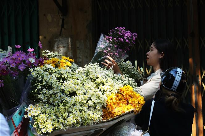 A Hanoi girl buying flowers on Thuy Khe street, Tay Ho district. VNA Photo: Lâm Khánh 